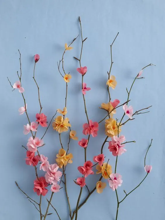 Papercraft. DIY Paper Blossom attached to branches on blue background: 