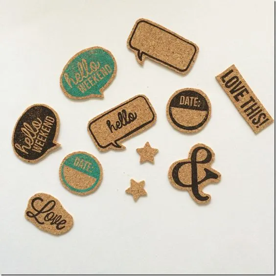Make these yourself. Buy cork sheet, stamp away, cut out, glue on.